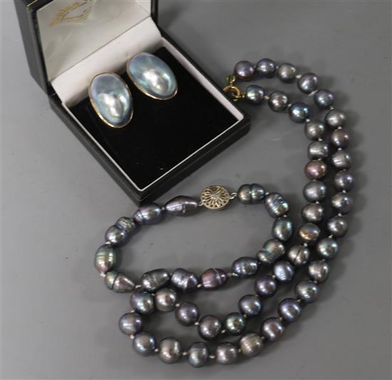 A single strand Tahitian? cultured pearl necklace, a similar bracelet and a pair of 9ct gold mounted earclips.